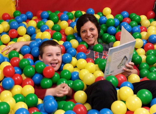 Therapist and child having fun in a ball pit